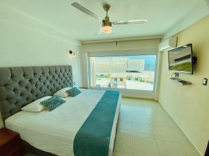 a bedroom with a large bed with a large window at FRENTE PLAYA vista al mar, PISCINA DE USO EXCLUSIVO in Boca del Río