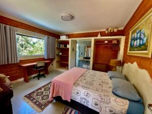 戈亚斯州上帕莱索Vila Amor - Charmosa e Central的一间卧室，里面有一张床、一张桌子和一扇窗户。