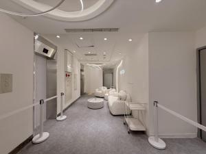 una sala d'attesa con sedie bianche e un parrucchiere di 在家行旅 南西館 a Taipei