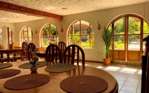 una sala da pranzo con tavolo, sedie e finestre di Casa De paz a Písac