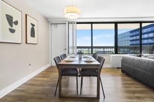 a dining room with a table and chairs and a large window at Stylish Apt in Crystal City in Arlington