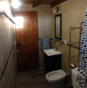 a bathroom with a sink and a toilet and a mirror at La casa de Yoni in Las Toninas