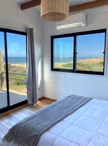 a bedroom with a bed with a view of the ocean at Casa frente al mar Papaya Grande in Punta Del Diablo +34 photos