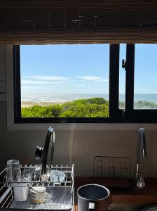 a drying rack in a kitchen with a window at Casa frente al mar Papaya Grande in Punta Del Diablo