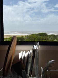 a view of the ocean from a window with chairs at Casa frente al mar Papaya Grande in Punta Del Diablo