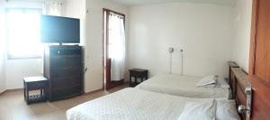 杜伊塔马Hotel Esmeralda Duitama的一间卧室，配有两张床和一台平板电视