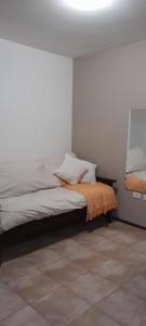 Un dormitorio con una cama con una manta naranja. en Descanso, en Paraná