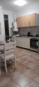 y cocina con mesa, sillas y fogones. en Descanso, en Paraná