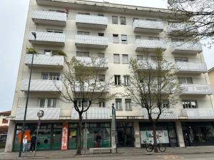 a tall white building with trees in front of it at Ca Re Dante in Pordenone