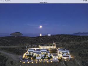 a large building on a hill with the moon in the sky at Astrio Suites in Livadi
