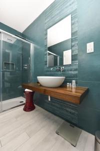 a bathroom with a sink and a mirror and a shower at Quaint Boutique Hotel Xewkija in Xewkija