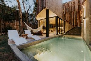 a pool with two chairs and a hammock next to a house at Media Luna BoHo Chic Villa E11 Pvt Pool Concierge in Tulum +28 photos