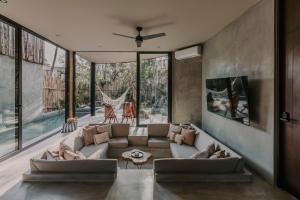 a living room with a couch and some windows at Media Luna BoHo Chic Villa E11 Pvt Pool Concierge in Tulum