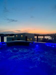 a hot tub with blue lighting in a backyard at Seaside Villa with outdoor Jacuzzi in Haugesund