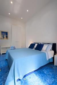a bedroom with a large bed with blue and white sheets at Il Sogno in Erchie +48 photos