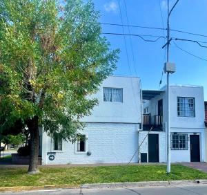 a white house with a tree in front of it at Merlo INK2 in Merlo