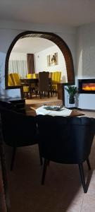 a living room with a table and yellow chairs at Vila Silvana in Moieciu de Jos