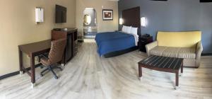 a hotel room with a bedroom with a bed and a desk at Deluxe Inn & Suites in York
