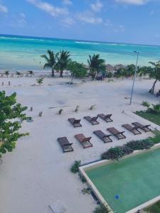 マアウアルにあるOceanfront 2Bed - 2Bath Paradise Mahahualのビーチの空中の景色を望む客室で、椅子、プールが備わります。