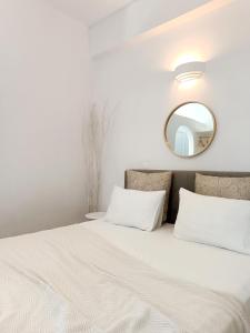 una camera da letto con un letto con uno specchio sulla parete di Apanema Paros a Naoussa