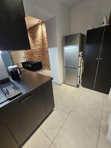 a kitchen with a stainless steel refrigerator and tile floor at 9Wygodny pokoj w centrum Wroclawia in Wrocław