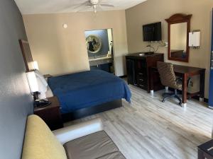 a hotel room with a bed and a desk and a computer at Deluxe Inn & Suites in York