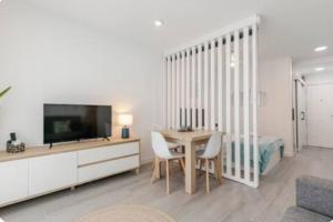 a living room with a dining room table and a television at CaLaNu Cap Salou Apartment by the sea in Salou