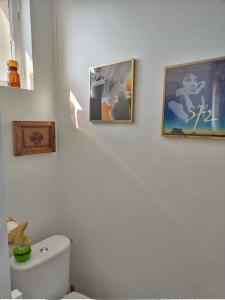 ein Badezimmer mit zwei Bildern an der Wand und einem WC in der Unterkunft Le vintage, 10 min de Disneyland, 30 min de Paris - 50 m gare- 30 min CDG aéroport in Esbly + 28 Fotos