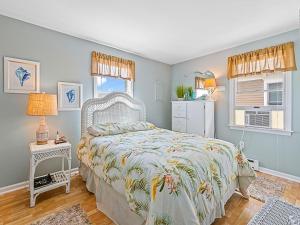 ein Schlafzimmer mit einem Bett und einem Tisch und zwei Fenstern in der Unterkunft Wifi, Outdoor Shower, Deck, Ocean Side 2Nd Floor Duplex Ocean Side 1St Floor Duplex, A Short Walk From The Best Lbi Attractions, A Small Park, And, in Beach Haven