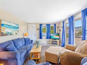 ein Wohnzimmer mit einem blauen Sofa und einem Fernseher in der Unterkunft Wifi, Outdoor Shower, Deck, Ocean Side 2Nd Floor Duplex Ocean Side 1St Floor Duplex, A Short Walk From The Best Lbi Attractions, A Small Park, And, in Beach Haven