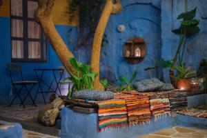 a blue room with a bed with colorful blankets at Mayelia Ηouse in the old town in Rhodes Town
