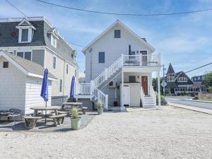 ein weißes Haus mit einem Tisch und einer Terrasse in der Unterkunft Wifi, Outdoor Shower, Deck, Ocean Side 2Nd Floor Duplex Ocean Side 1St Floor Duplex, A Short Walk From The Best Lbi Attractions, A Small Park, And, in Beach Haven