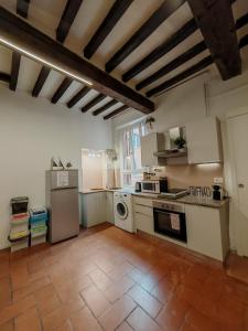 a kitchen with white appliances and a tile floor at La sosta 2-Casa accanto alla stazione dei treni in Modena