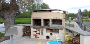 an outdoor oven on the back of a boat at Espace au calme au bord d'un plan d'eau in Beaufay