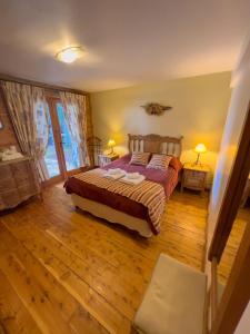 Un dormitorio con una cama y una ventana grande. en Cabañas Rincon del Lago, en Villa La Angostura