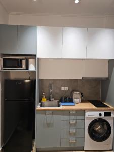a kitchen with white cabinets and a sink and a dishwasher at Elegant City Retreat Walk to Landmarks & Metro in Athens