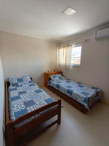 a bedroom with two beds and a window at Quarto em Caruaru para o São João in Caruaru