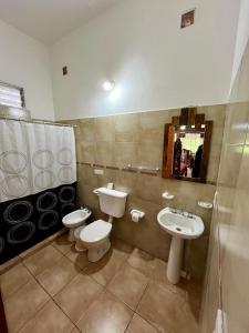 a bathroom with a sink and a toilet and a mirror at Departamentos La Morita in Embalse