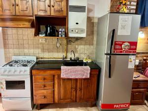 a kitchen with a refrigerator and a sink at Departamentos La Morita in Embalse