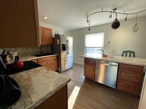 une cuisine avec des appareils en acier inoxydable et des armoires en bois dans l'établissement Blue Betty- 3 BDRM Mid-Century Charmer Near Beach, à Brigantine