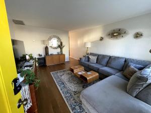 un salon avec un canapé et une table dans l'établissement Blue Betty- 3 BDRM Mid-Century Charmer Near Beach, à Brigantine