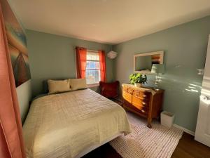 une chambre avec un lit, une commode et un miroir dans l'établissement Blue Betty- 3 BDRM Mid-Century Charmer Near Beach, à Brigantine