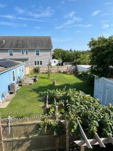 une arrière-cour avec une clôture et une maison dans l'établissement Blue Betty- 3 BDRM Mid-Century Charmer Near Beach, à Brigantine