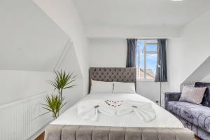 ein Schlafzimmer mit einem Bett mit einer Schleife darauf in der Unterkunft Wembley Business & Pet Haven - Parking, Fully Equipped, 6x in Colindale