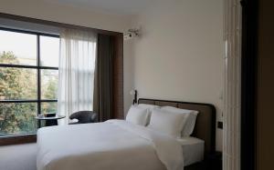 Postel nebo postele na pokoji v ubytování The Moment Hotel