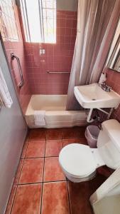 a bathroom with a toilet and a tub and a sink at vogue motel in South Gate +11 photos