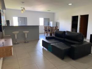 un soggiorno con un divano nero e una cucina di Apartamento Caiçaras a Belo Horizonte Altre 15 foto