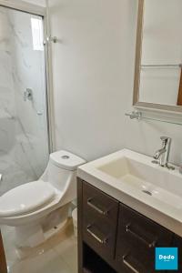 a white bathroom with a toilet and a sink at Residencial a 5 min. de plaza comercial in Mazatlán +21 photos