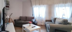 Una sala de estar con dos sofás y una mesa. en Céntrico espacioso y muy luminoso, en Villasana de Mena