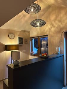 a kitchen with two lights and a table with a bowl of fruit at JP Motel Mali Pariz in Bor